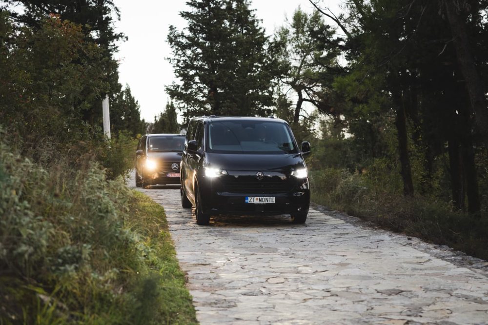 Two black Monte Zeta vans driving along a stone road in Montenegro